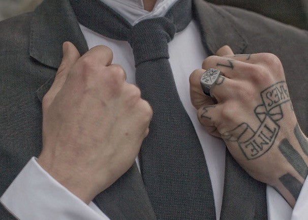 Man with signet ring and tattoos